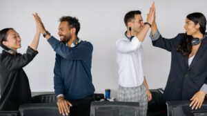 Equipe de atendimento comemorando juntos em um ambiente de escritório
