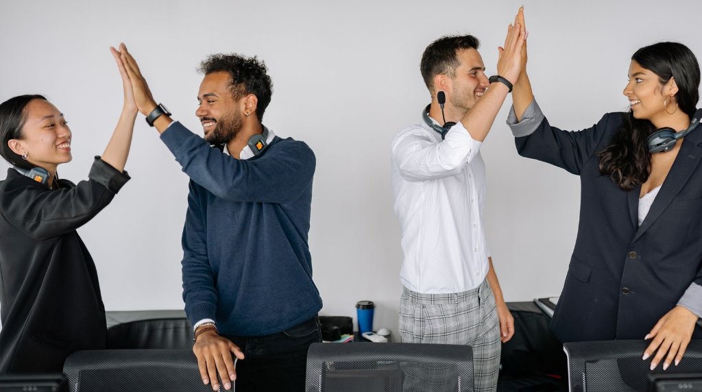 Equipe de atendimento comemorando juntos em um ambiente de escritório