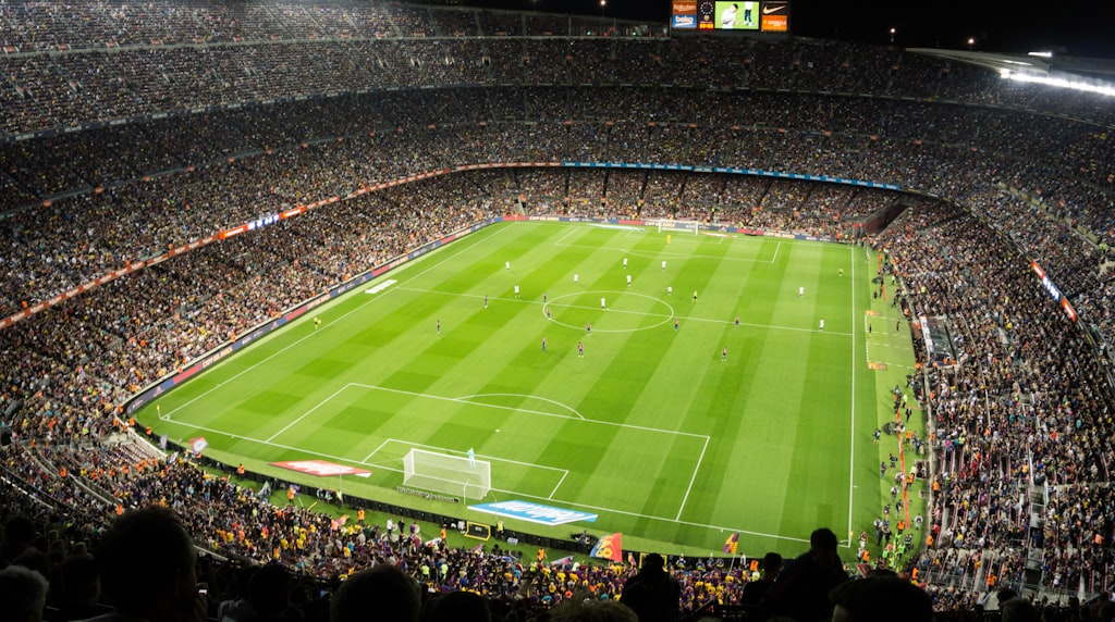 Torcedores acompanhando um jogo de futebol no estádio