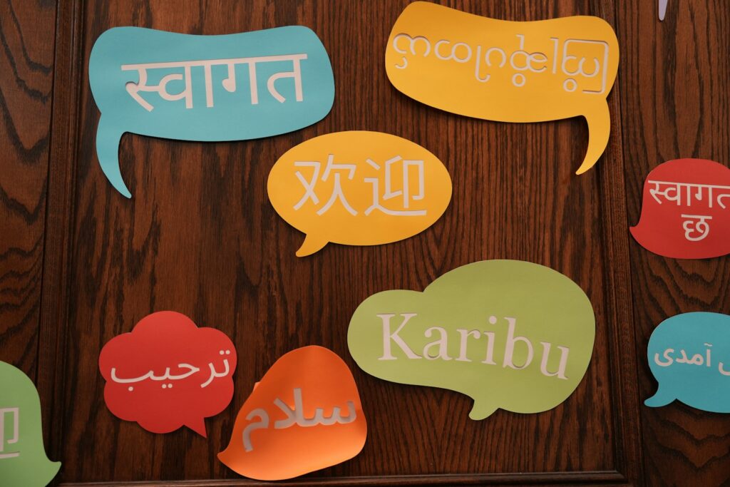 Baloes de fala coloridos com saudacoes em varios idiomas numa parede de madeira, representando o publico multilingue do ChatGPT