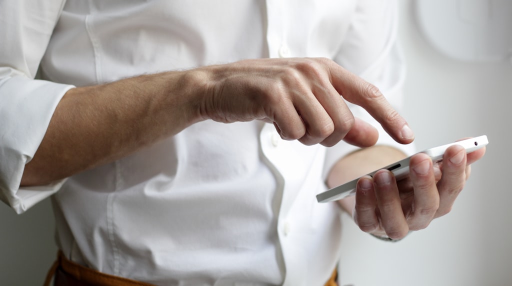 Pessoa tocando a tela do celular, gesto de abrir o painel de informacoes de um anuncio