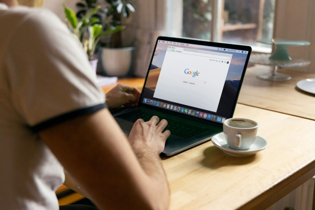 Pessoa em um notebook com a pagina de busca do Google aberta, ilustrando os testes de resumos de IA nos anuncios de Search