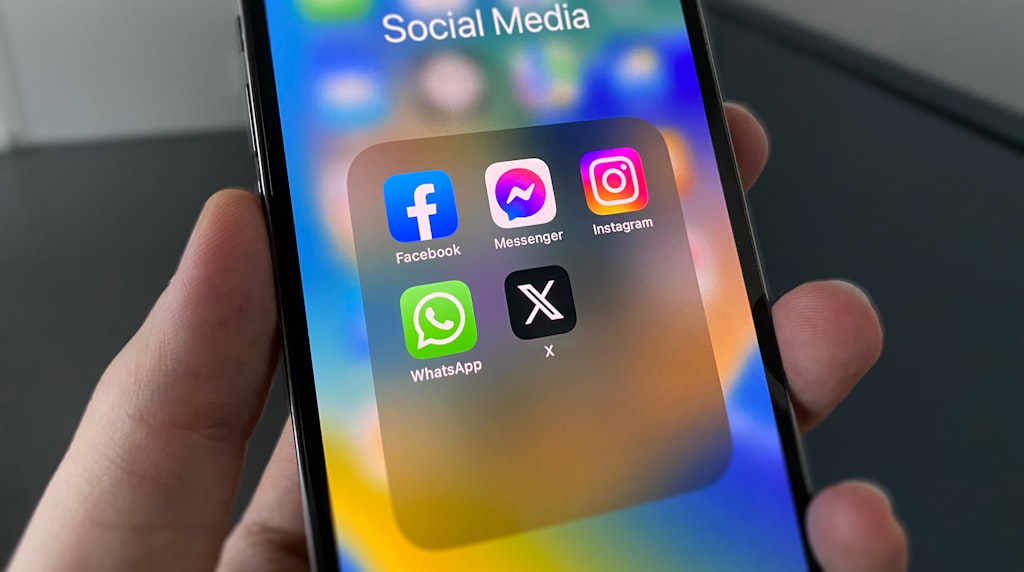 Pessoa segurando celular com redes sociais na tela