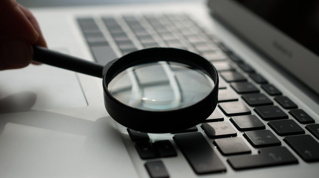 Lupa sobre um laptop, simbolizando auditoria técnica