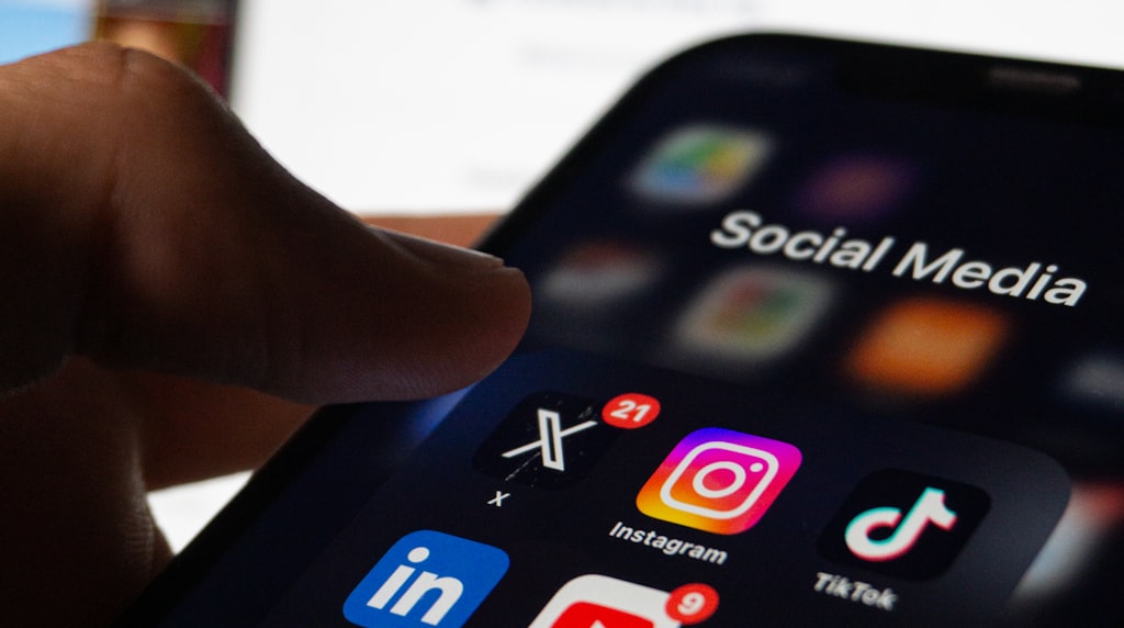 Pessoa segurando um smartphone com rede social na tela