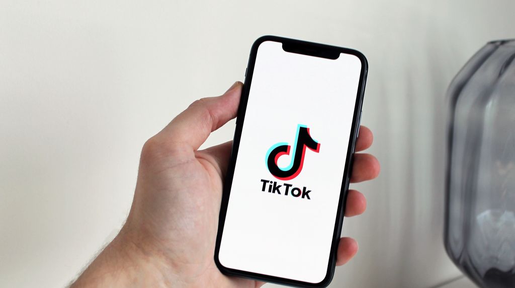 Mão segurando o smartphone com o aplicativo do TikTok