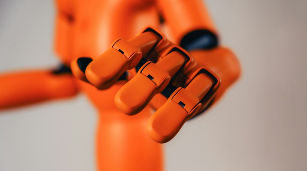 Agentes de IA autonomos: braco robotico laranja se estendendo em direcao a algo fora do alcance