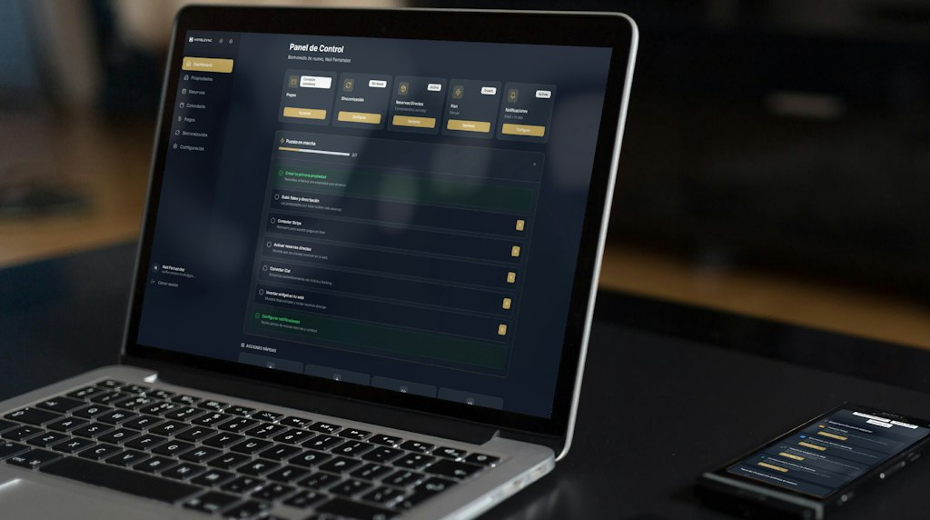 Notebook exibindo painel de dados financeiros ao lado de um celular