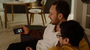 Duas pessoas sentadas assistindo a um video pelo smartphone