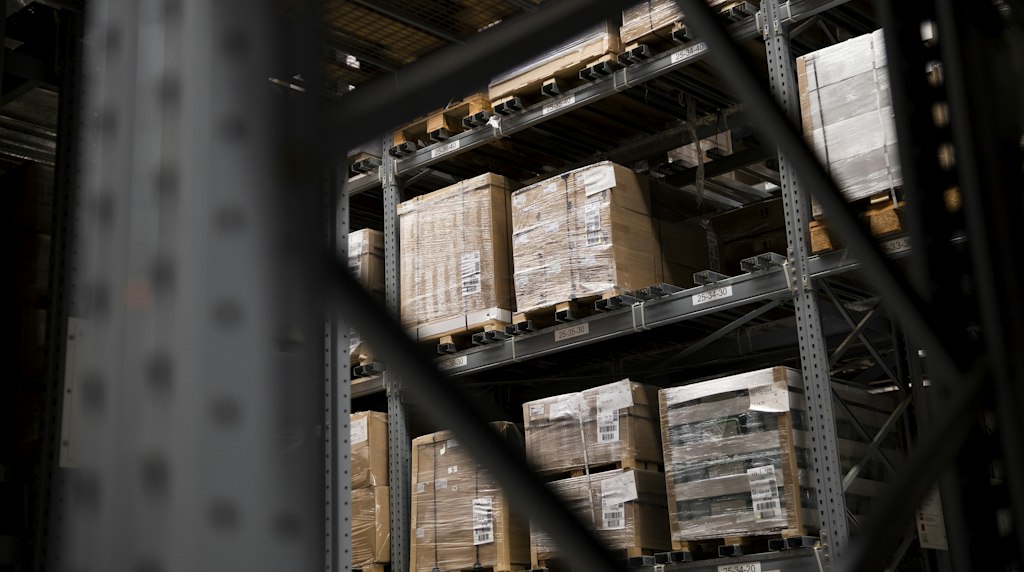 Armazém de e-commerce com prateleiras cheias de caixas e paletes