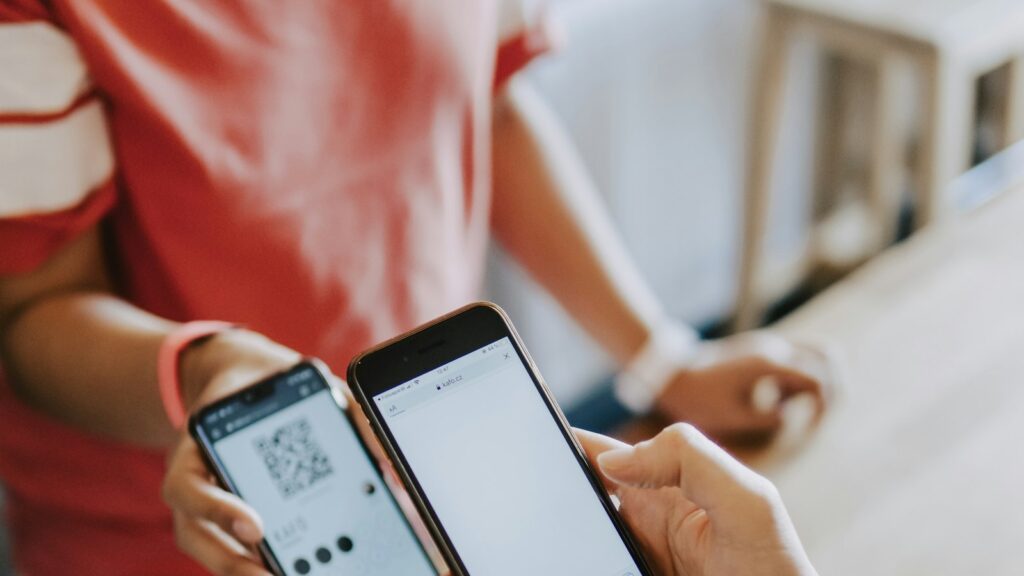 Duas pessoas concluindo uma compra direto pelo celular, com QR code e tela de pagamento, ilustrando a compra assistida por IA que o Google está testando com a Flipkart
