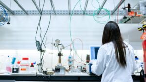 Cientista de jaleco branco usando laptop em um laboratorio
