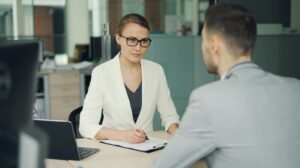 Entrevista de pesquisa entre duas pessoas em uma mesa de escritorio