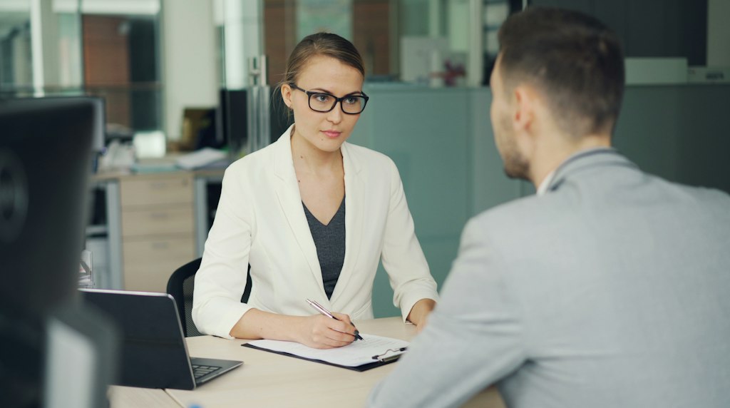 Entrevista de pesquisa entre duas pessoas em uma mesa de escritorio
