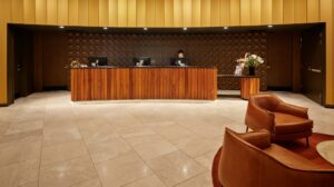 Recepção de hotel com balcão e mobiliário claro, como porta de entrada de atendimento