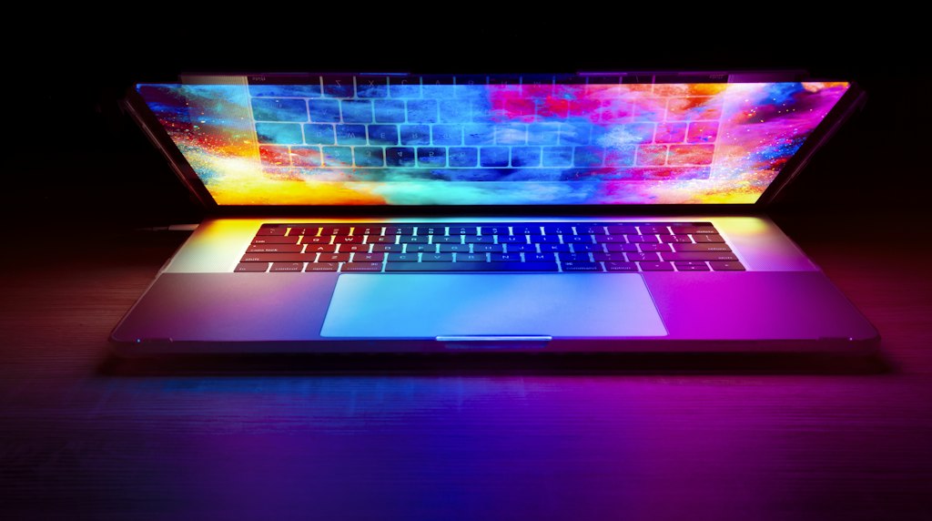 Laptop com tela colorida sobre uma mesa de madeira