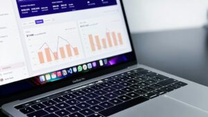 Mesa de trabalho com notebook exibindo gráficos de desempenho de uma loja virtual