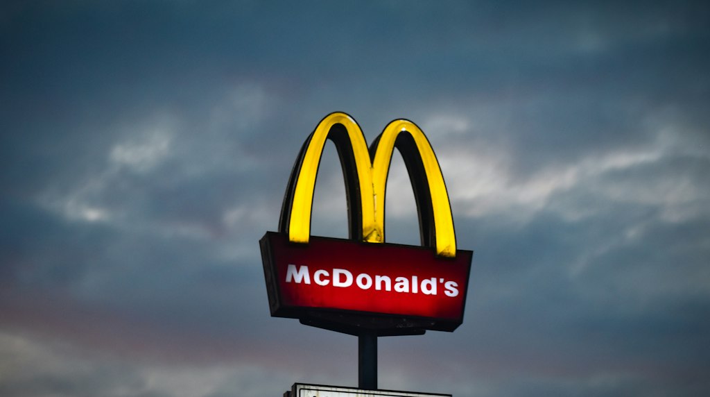 Placa do McDonald's com céu nublado ao fundo