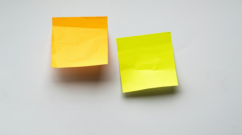 Post-its amarelos colados em uma parede branca, simbolizando memória e lembretes