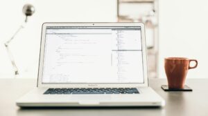 Mesa de trabalho com notebook exibindo planilha e gráficos usados para organizar e acompanhar métricas de busca