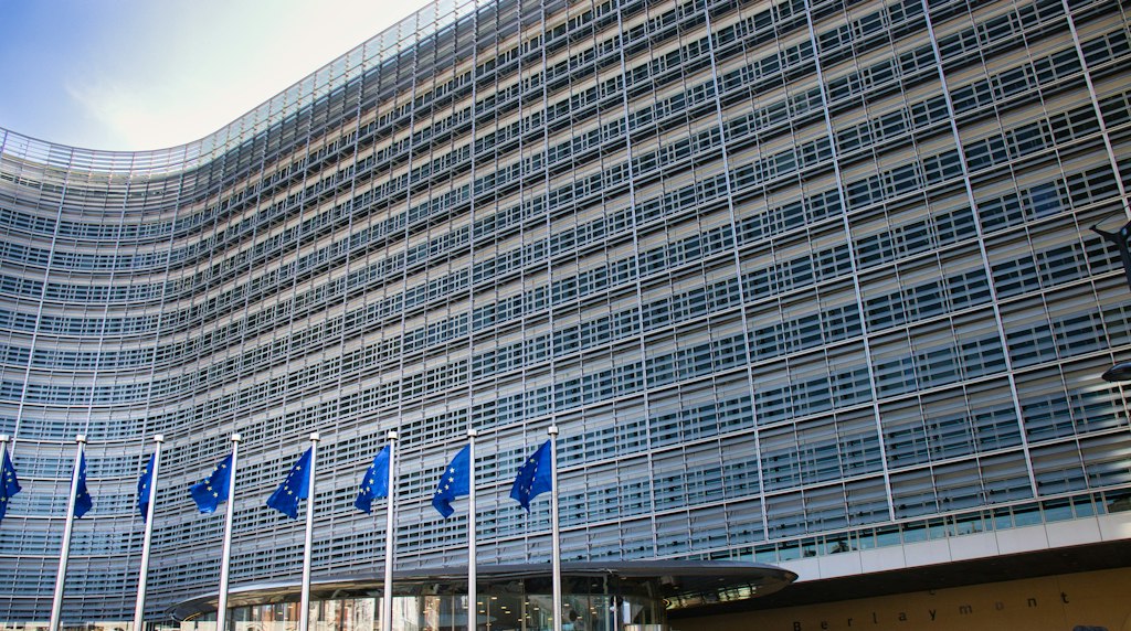 Edifício de vidro moderno com bandeiras da União Europeia