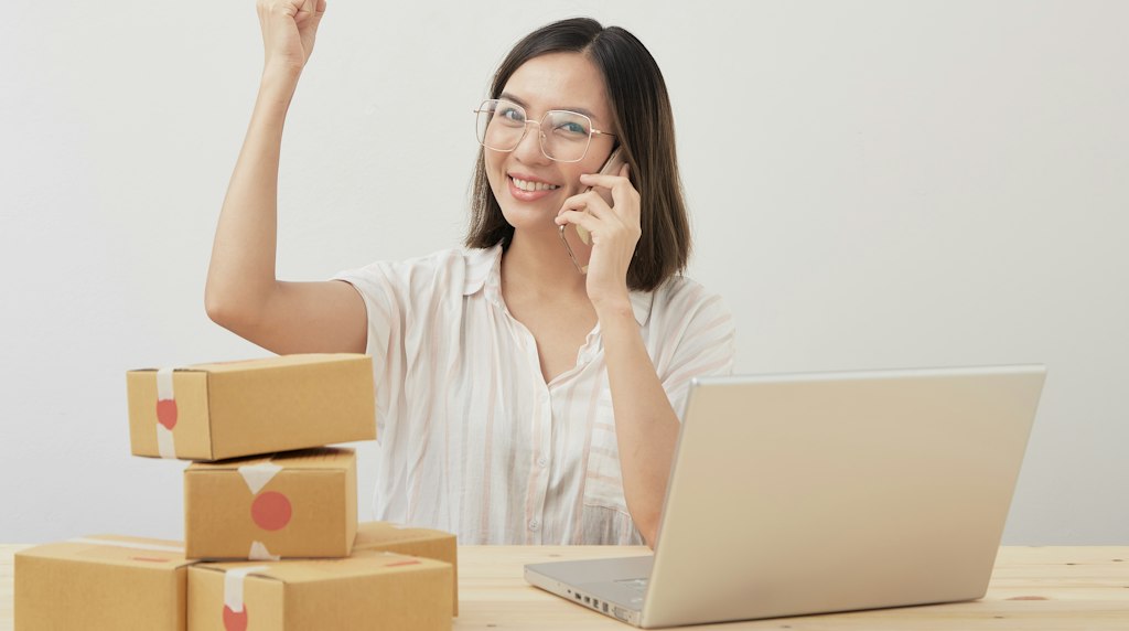 Mulher sentada diante de um notebook fazendo compras online