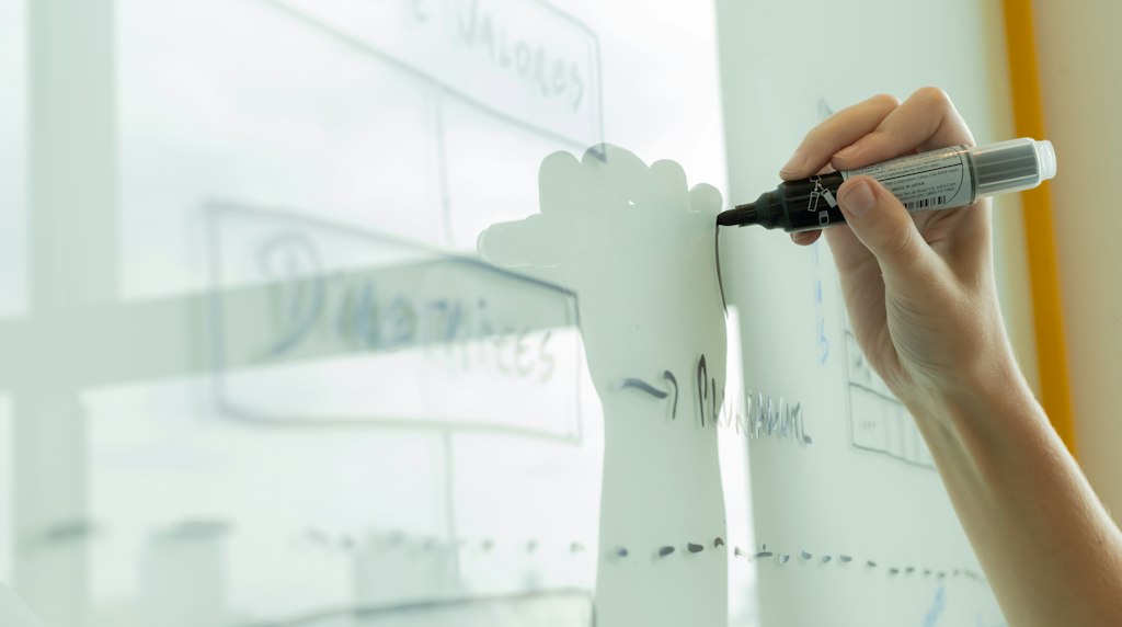 Mão desenhando um diagrama de planejamento em um quadro