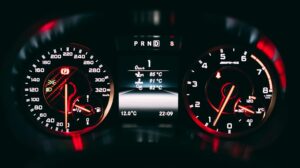 Velocímetro analógico preto e vermelho em close