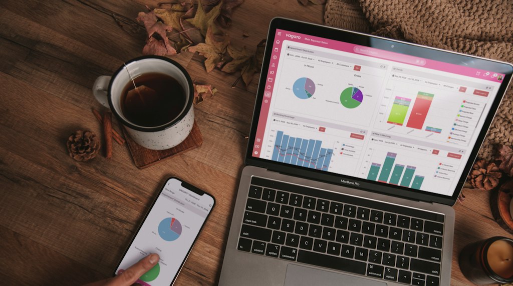 Notebook e smartphone exibindo painéis analíticos sobre uma mesa