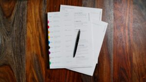 Pilha de papéis e documentos sobre uma mesa de trabalho