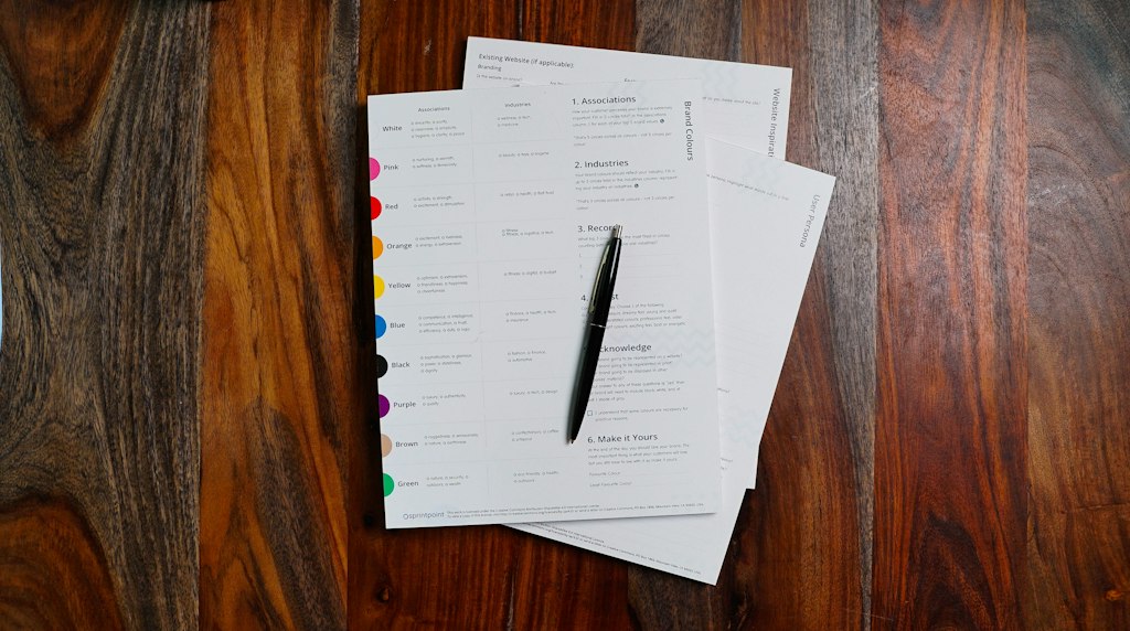 Pilha de papéis e documentos sobre uma mesa de trabalho