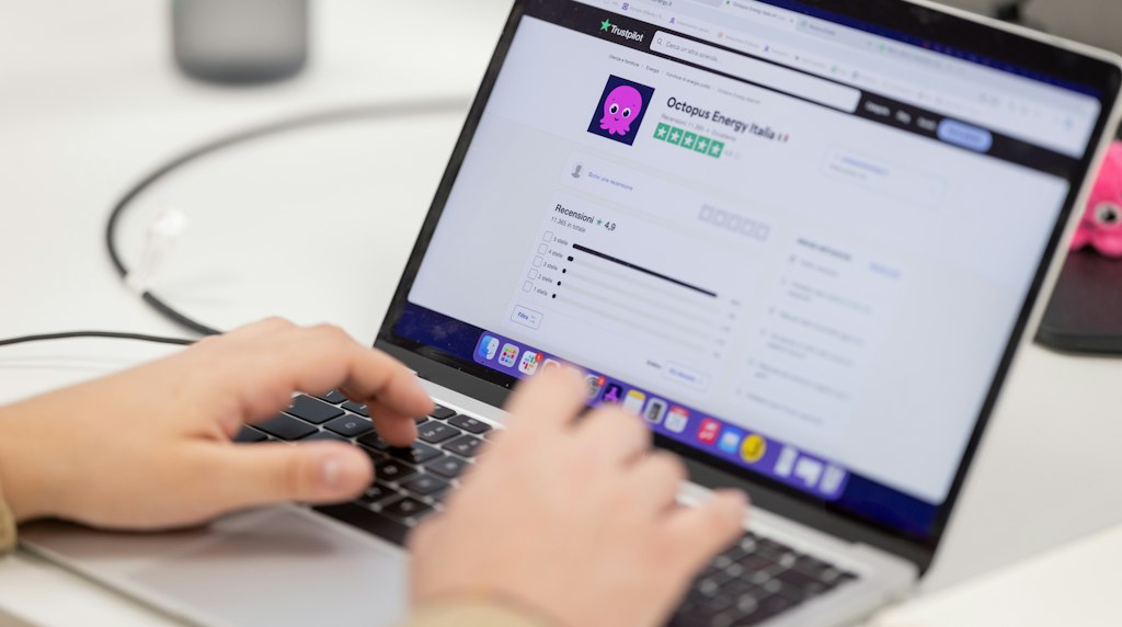 Pessoa digitando em um computador, lendo avaliações e comentários sobre uma marca