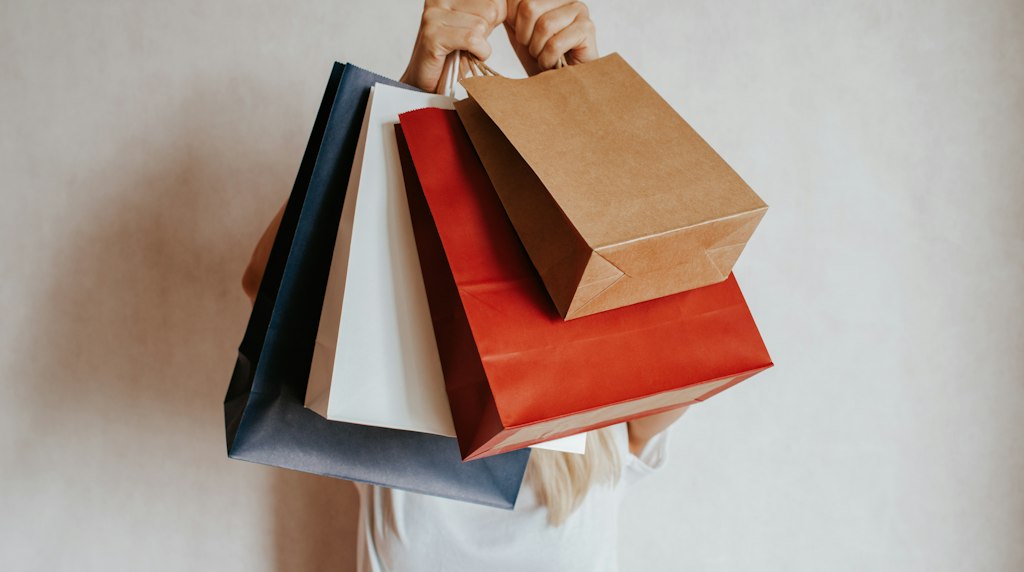 Pessoa segurando sacolas de compras, representando o cliente que volta a comprar na loja